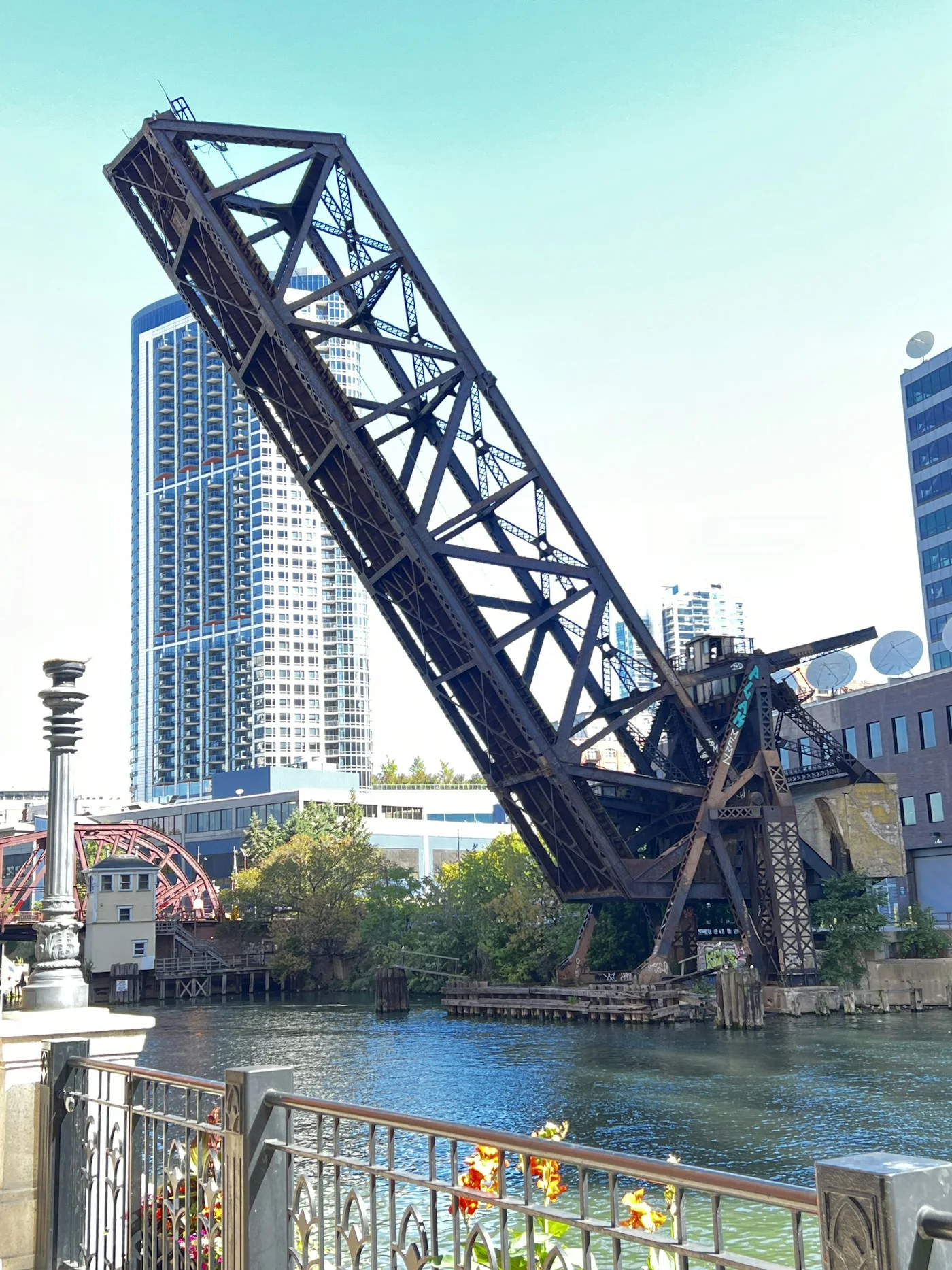 A raised steel bridge viewed from the Chicago Riverwalk