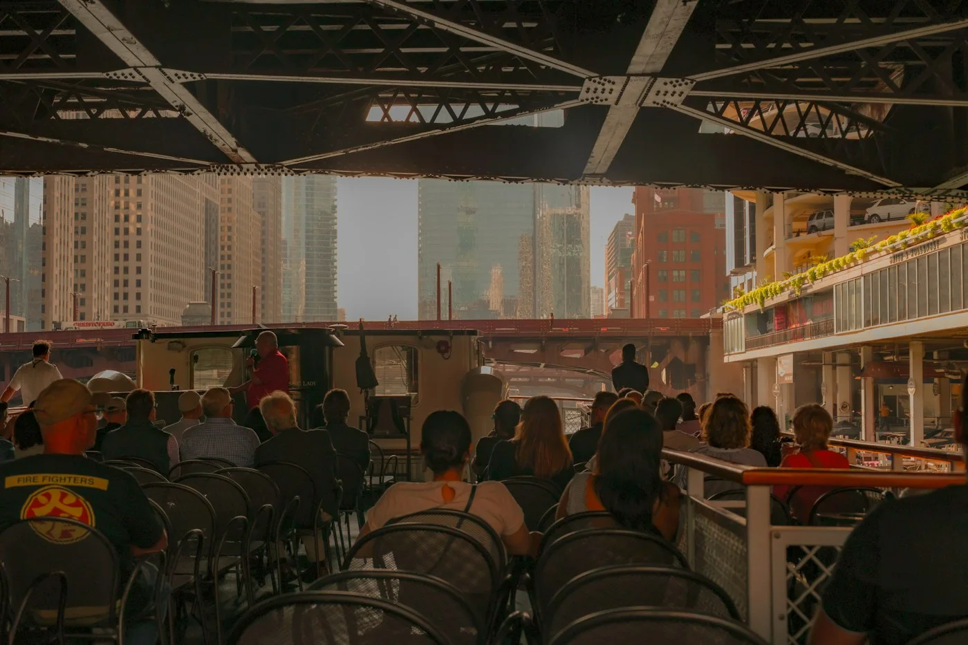 People seated at a riverside cafe beneath a Chicago bridge