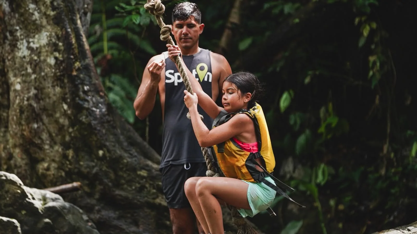 A guide assisting a child on the rope swing