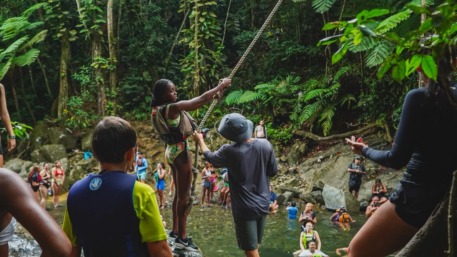 A guide helping a traveler with the rope swing
