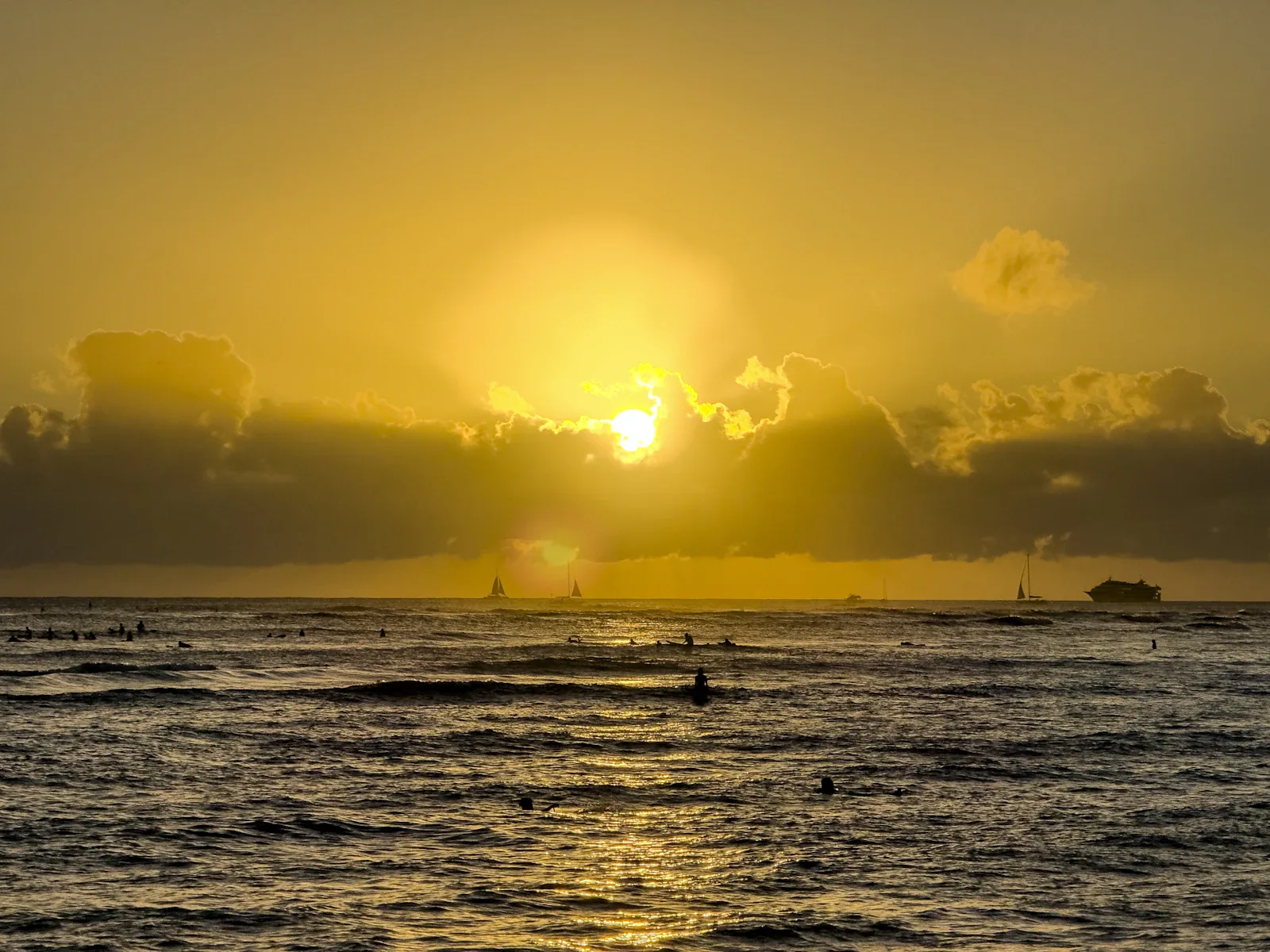 Surfers in the water at sunset in Waikiki
