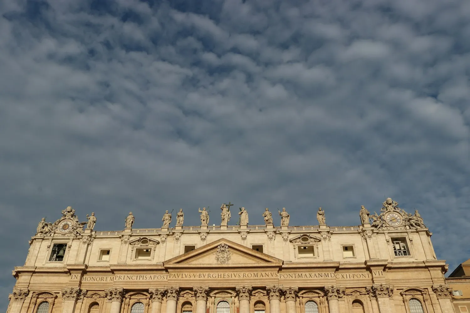 The basilica façade under passing clouds
